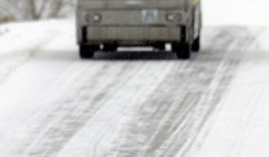 FILE - In this Jan. 26, 2002 file photo, a tour bus stops to let a wolf cross the road in Yellowstone National Park, Wyo. Wyoming is estimated to have at least 347 wolves roaming within its borders after the state regained management of the animals and allowed limited hunting of wolves. (AP Photo/Nati Harnik, File)