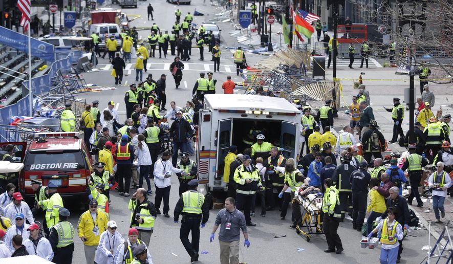 FILE - In this April 15, 2013 file photo, medical workers aid injured people following an explosion at the finish line of the 2013 Boston Marathon in Boston. Five years after the the bombings, federally funded community programs to prevent similar attacks by homegrown extremists are barely underway and face an uncertain future. (AP Photo/Charles Krupa, File)