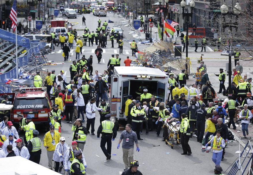 FILE - In this April 15, 2013 file photo, medical workers aid injured people following an explosion at the finish line of the 2013 Boston Marathon in Boston. Five years after the the bombings, federally funded community programs to prevent similar attacks by homegrown extremists are barely underway and face an uncertain future. (AP Photo/Charles Krupa, File)