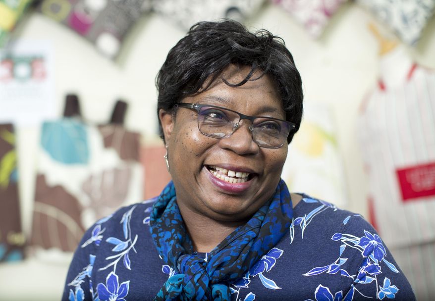 Pamela Anomneze, 52, reacts as she poses at Studio 360 Collective in Haringey, north London Tuesday April 10, 2018, after she received an invitation to the upcoming royal wedding of Prince Harry and Meghan Markle at Windsor Castle next month. Anomneze works with 306 Collective in London, which helps people with mental health issues by teaching them to create mugs, jewellery, textiles and other items. It will be friends and family along with members of the public on the guest list, rather than politicians and world leaders, at Prince Harry and Meghan Markle's wedding on May 19. (Isabel Infantes/PA via AP)