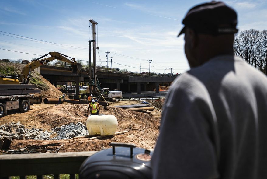 Nathaniel Allen stands on his side porch right next to the Business 40 construction Thursday, April 5, 2018, on Westdale Avenue in Winston-Salem, N.C. Allen said there's too much dust from the roadwork to even think about using his outdoor grill. "It gets noisy at times when they are drilling or blasting or something like that," Allen said. "It looks like they have a long way to go to get done." (Allison Lee Isley/The Winston-Salem Journal via AP)