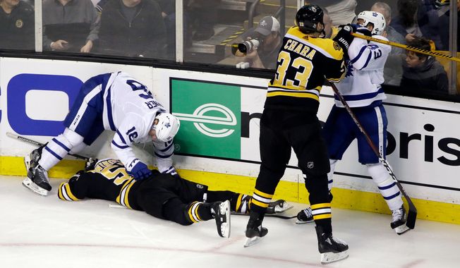 FILE - In this April 12, 2018, file photo, Boston Bruins defenseman Zdeno Chara (33) shoves Toronto Maple Leafs center Nazem Kadri (43) to retaliate for his late hit on Boston Bruins center Tommy Wingels (57), bottom left,  as Maple Leafs center Mitchell Marner (16) starts to get up during the third period of Game 1 of an NHL hockey first-round playoff series, in Boston. Through the first two days of the Stanley Cup playoffs, there have already been a handful of hits to the head, two ejections, one suspension and the possibility of more to come. (AP Photo/Elise Amendola)