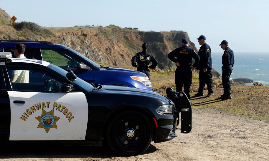 FILE - In this March 28, 2018, file photo, California Highway Patrol officers and deputy sheriffs from Mendocino and Alameda counties gather after a search for three missing children at the site where the bodies of Jennifer and Sarah Hart and three of their adopted children were recovered two days earlier, after the family's SUV plunged over a cliff at a pullout on the Pacific Coast Highway near Westport, Calif. Three of the children, Devonte Hart, 15, Hannah Hart, 16, and Sierra Hart, 12, have not been found. Authorities say a woman who drove off California cliff last month in an SUV carrying her wife and children was drunk. California Patrol Capt. Bruce Carpenter said Friday, April 13, 2018, that toxicology tests found Jennifer Hart had an alcohol level of .102. California drivers are considered drunk with a level of 0.08 or higher. Authorities don't know who was at the wheel at the time of the accident. (Alvin Jornada/The Press Democrat via AP, File)