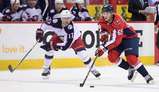 Washington Capitals left wing Andre Burakovsky (65) skates with the puck against Columbus Blue Jackets center Brandon Dubinsky (17) during the first period in Game 1 of an NHL first-round hockey playoff series, Thursday, April 12, 2018, in Washington. (AP Photo/Nick Wass)