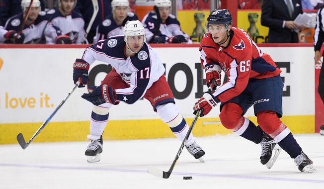 Washington Capitals left wing Andre Burakovsky (65) skates with the puck against Columbus Blue Jackets center Brandon Dubinsky (17) during the first period in Game 1 of an NHL first-round hockey playoff series, Thursday, April 12, 2018, in Washington. (AP Photo/Nick Wass)