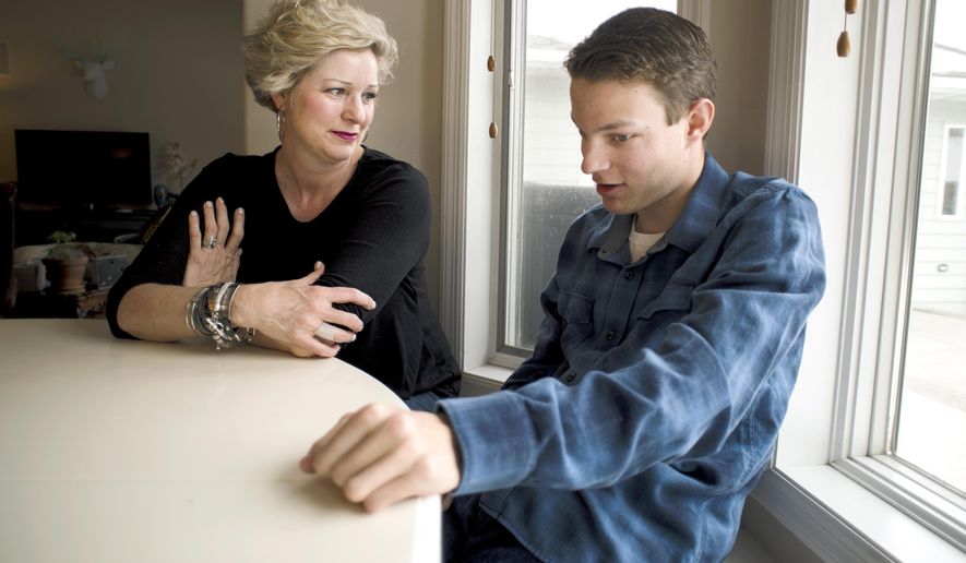 In this Wednesday, April 4, 2018 photo, Derek Seymour, 20, right, talks with his mother Kelly in Four Corners, Mont. Derek says he helped his father make the bench he's sitting on in their home. Montana State University is launching a program offering new opportunity and hope to students with disabilities, like Derek, with a chance to go to college and learn job skills. (Freddy Monares/Bozeman Daily Chronicle via AP)