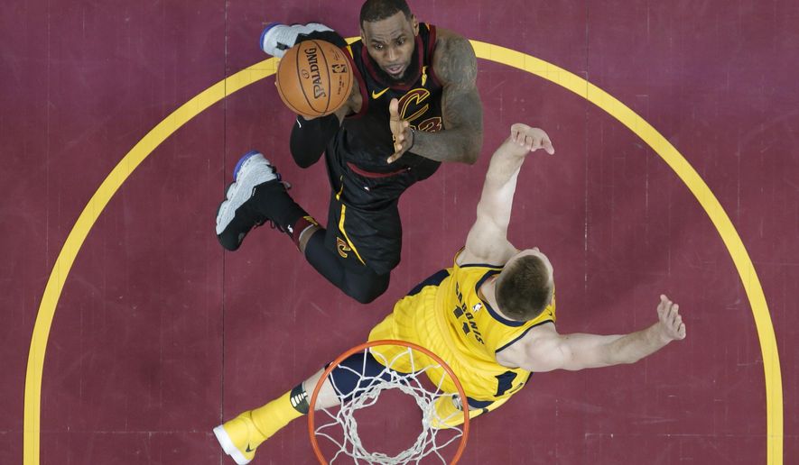 Cleveland Cavaliers' LeBron James, top, drives against Indiana Pacers' Domantas Sabonis, from Lithuania, in the first half of Game 1 of an NBA basketball first-round playoff series Sunday, April 15, 2018, in Cleveland. (AP Photo/Tony Dejak)