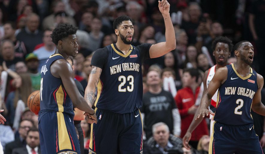 New Orleans Pelicans guard Jrue Holiday, forward Anthony Davis and guard Ian Clark celebrate a score against the Portland Trail Blazers during the second half in Game 1 of an NBA basketball first-round playoff series Saturday, April 14, 2018, in Portland, Ore. New Orleans won 97-95. (AP Photo/Randy L. Rasmussen)