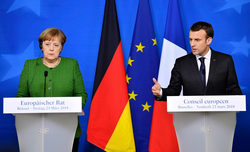 FILE - In this March 23, 2018, file photo, French President Emmanuel Macron, right, and German Chancellor Angela Merkel speak at a news conference in Brussels. The future of the landmark Iran nuclear deal hangs in the balance and its survival may depend on the unlikely success of last-minute European interventions with President Donald Trump. Macron and Merkel are to visit Washington separately later in April and will likely be the last foreign leaders invested in the deal to see Trump ahead of his mid-May deadline for the accord to be strengthened. (AP Photo/Geert Vanden Wijngaert, File)