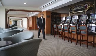 Hamza Mustafa, the CEO of Dubai’s Ports, Customs and Free Zone Corp.’s investment arm, passes slot machines that will remain turned off as gambling is illegal, aboard the Queen Elizabeth 2, moored off the Mideast city-state of Dubai, United Arab Emirates, Tuesday, April 17, 2018. Britain&#39;s famed luxury cruise ship finally will have a soft opening Wednesday as a floating luxury hotel nearly a decade after arriving here following her last ocean voyage. (AP Photo/Kamran Jebreili)