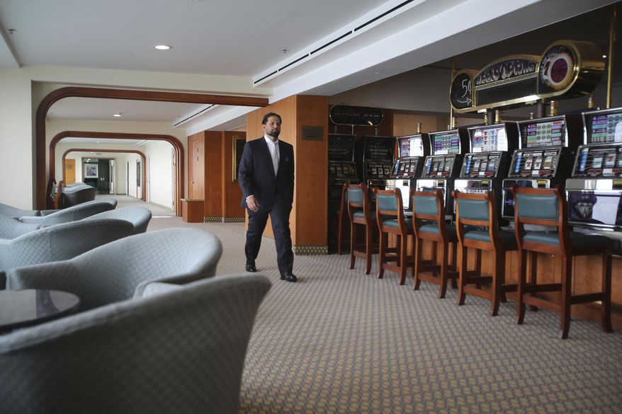 Hamza Mustafa, the CEO of Dubai’s Ports, Customs and Free Zone Corp.’s investment arm, passes slot machines that will remain turned off as gambling is illegal, aboard the Queen Elizabeth 2, moored off the Mideast city-state of Dubai, United Arab Emirates, Tuesday, April 17, 2018. Britain&#39;s famed luxury cruise ship finally will have a soft opening Wednesday as a floating luxury hotel nearly a decade after arriving here following her last ocean voyage. (AP Photo/Kamran Jebreili)