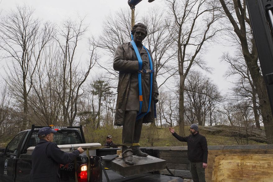 The statue of Dr. J. Marion Sims, is removed by crane, Tuesday, April 17, 2018, in New York's Central Park. Sims was known as the father of modern gynecology, but critics say his use of enslaved African-American women as experimental subjects was unethical. The statue is being moved to Green-Wood Cemetery in Brooklyn, where Sims is buried. (AP Photo/Mark Lennihan)