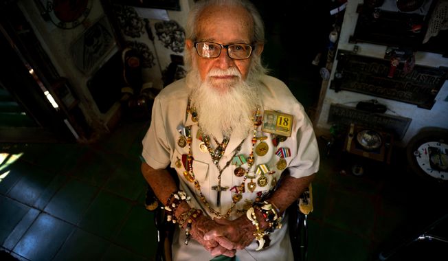 In this April 12, 2018 photo, artist and former diplomat Hector Pascual Gallo Portieres poses at his home in the Alamar public housing complex in Havana, Cuba. The barber by profession was approached in 1960 to go on a mission to find out how the U.S. would attack Cuba. He found answers in Costa Rica, and was highly decorated for alerting Cuba to the 1961 U.S. invasion of the Bay of Pigs. After years in diplomacy, he returned home to teach intelligence and retired after 30 years. Gallo, now 93, says he hopes the next generation will be faithful to national hero Jose Marti and to the process Fidel Castro started. (AP Photo/Ramon Espinosa)