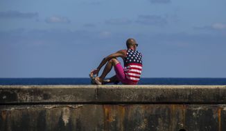 A man wearing a shirt with the stars and stripes sits on the Malecon in Havana, Cuba, Wednesday, April 18, 2018. Cuba&#39;s legislature opened today a two-day session that is to elect a successor to President Castro. (AP Photo/Desmond Boylan)