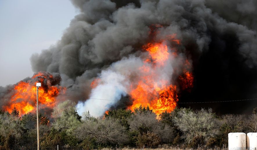 In this Tuesday, April 17, 2018, heavy smoke billows from burning trees after a wildfire broke out in a farm field along US Highway 183 about 10 miles south of Seiling, Okla. (Jim Beckel/The Oklahoman via AP)