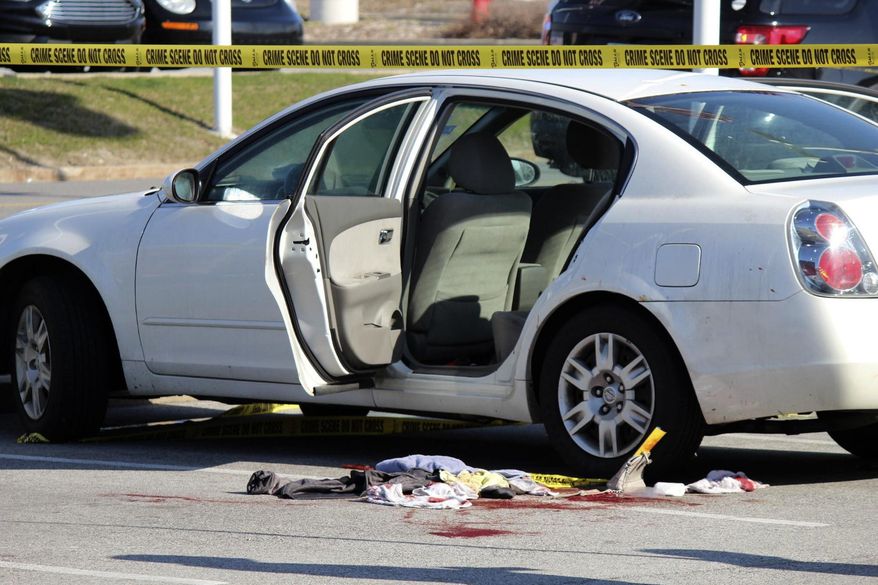 In this Tuesday, April 17, 2018 photo, police tape surrounds the scene where a 3-year-old girl accidentally shot and wounded her pregnant mother in a car parked outside a northwestern Indiana thrift store. The shooting happened Tuesday afternoon in Merrillville, Ind., as the girl, a 1-year-old boy and her mother waited in the car while the woman's boyfriend was inside the store. Police say the man is the girl's father and apparently left the loaded gun in the car. (Rob Earnshaw/The Times via AP)