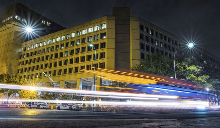 FILE - In this Nov. 1, 2017, file photo, traffic along Pennsylvania Avenue in Washington streaks past the Federal Bureau of Investigation headquarters building. In the two weeks since the #Releasethememo hashtag first sprouted on Twitter, a secret congressional report on the Russia investigation has gone from an obscure, classified document to a bitter point of conflict between not only Democrats and Republicans but also the White House and the FBI. (AP Photo/J. David Ake)