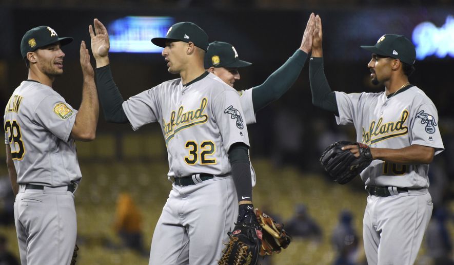 Oakland Athletics' Matt Olson, Trayce Thompson, left, Matt Chapman and Marcus Semien, from left, celebrate beating the Los Angeles Dodgers 16-6 during a baseball game, Wednesday, April 11, 2018, in Los Angeles. (AP Photo/Michael Owen Baker)