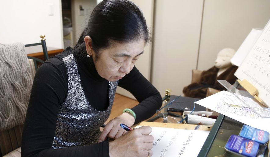 In this March 7, 2018, photo, retired harpist Yumi Makino practices western calligraphy in her apartment room in Tokyo. Makino won a two-year legal battle to get out of a senior citizens home she hated and get her deposit money back in a rare victory over a big real estate company. Her experience reflects the challenges many older Japanese face in finding suitable care and accommodations in “super-aging” Japan, the world’s No. 1 aging nation. (AP Photo/Yuri Kageyama)