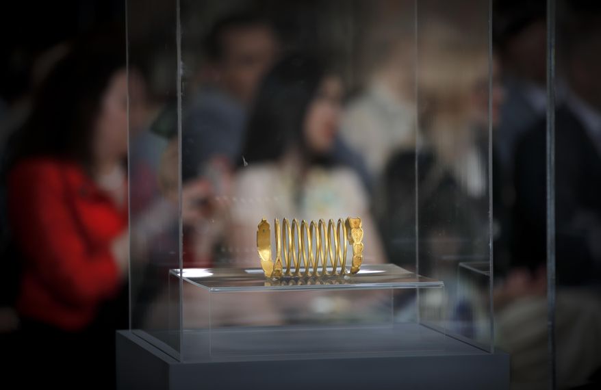 An ancient Dacian gold bracelet is displayed during a press conference at the national history museum in Bucharest, Romania, Thursday, April 19, 2018. A treasure trove of coins and bracelets from the 1st century that were stolen from archeological sites in western Romania and illegally smuggled out of the country has been put on display after being recovered in Austria during a cross-border investigation.(AP Photo/Vadim Ghirda)
