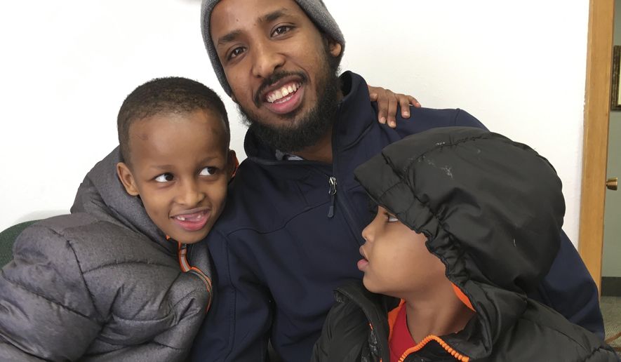 In this March 12, 2018  photo, Abdisalan Mohamed Jele, 31, poses for a picture with his two sons, Hamza Abdisalan Mohamed, 7, left, and Mohamed-Amin Abdisalan Mohamed, 4, at his attorney&#x27;s office in St. Cloud, Minn. Jele and the boys are U.S. citizens of Somali descent. He brought his boys to the U.S. in October, expecting his wife would follow with the couple&#x27;s baby girl. Months later, the family is still separated due to the travel ban. (AP Photo/Amy Forliti)
