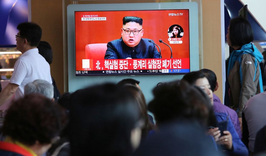 In this April 21, 2018, file photo, people watch a TV screen showing an image of North Korean leader Kim Jong-un during a news program at the Seoul Railway Station in Seoul, South Korea. The signs read: "North Korea says it has suspended nuclear tests." (AP Photo/Ahn Young-joon, File)