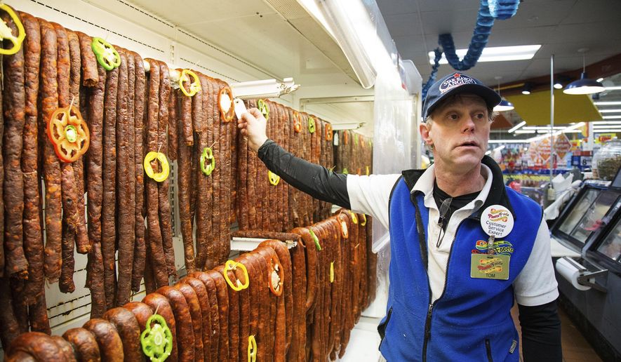 In a Wednesday, March 22, 2018 photo, meat manager Tom Smith discusses the date tagging process used in a cold storage case of chorizo and longanzia at Fiesta Foods in Yakima, Wash. The spicy sausage is known for its starring role in many Mexican breakfast dishes, like Fajardo's family uses. But in the past several years, as it's become more mainstream, foodies have started putting it in everything from burgers to soups. (Shawn Gust/Yakima Herald-Republic/via AP)