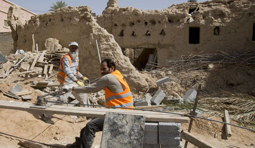 In this March 8, 2018 photo, workers restore the Al Sarreha Mosque in the 18th century Diriyah fortified complex, that once served as the seat of power for the ruling Al Saud, in Riyadh, Saudi Arabia. The UNESCO World Heritage site lies in a conservative, arid patch of the country and is unlikely to feature high on any bucket lists for world travelers, but the kingdom is hoping to alter perceptions as it prepares to open the country to tourist visas and international tour groups later this year.(AP Photo/Amr Nabil)