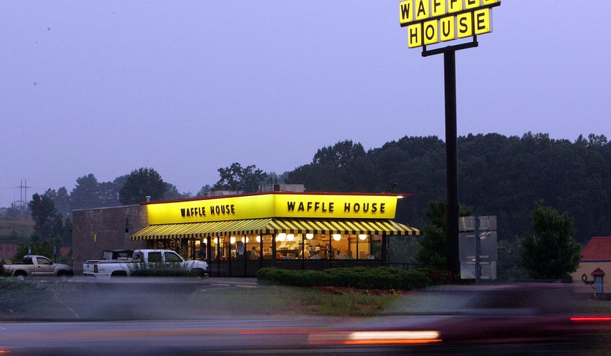 Traffic flashes by breakfast diners a a Waffle House near Dawsonville, Ga., Thursday, July 28, 2005. The eating establishment is open 24/7 everyday. There are 1,500 Waffle Houses spread across 25 states, as far west as Arizona and as far north as Illinois, but the chain is still rooted deeply in the South and retains a distinctively down-home, blue-collar aura. (AP Photo/Ric Feld)