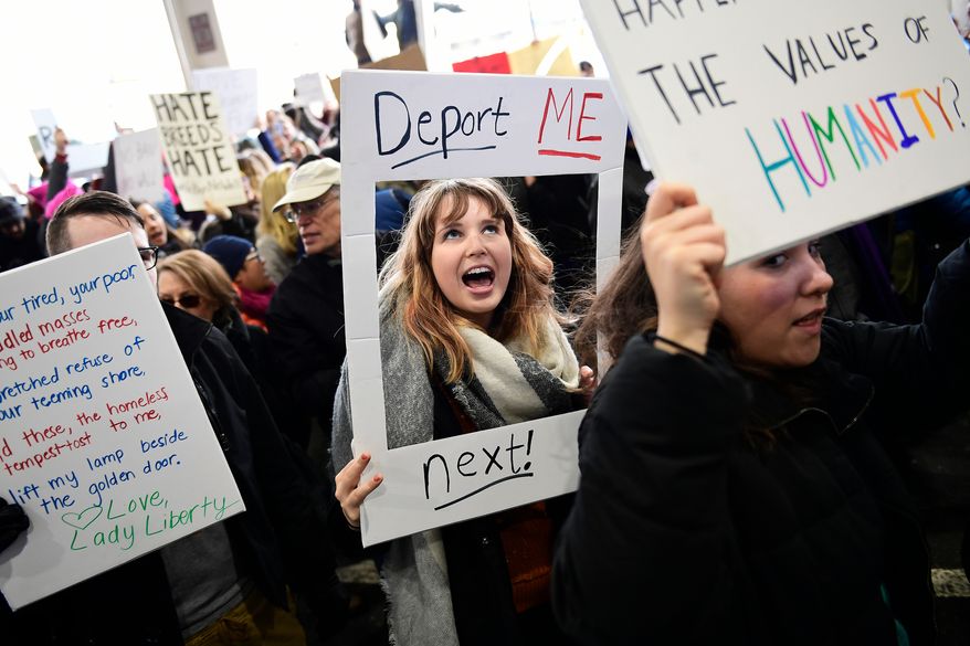 In this Sunday, Jan. 29, 2017, file photo, Madison Gray, a Temple University student, holds up a sign during a protest against President Donald Trump&#39;s executive order banning travel to the U.S. by citizens of Iraq, Syria, Iran, Sudan, Libya, Somalia or Yemen, at Philadelphia International Airport in Philadelphia. More than five decades after Americans poured into the streets to demand civil rights and the end to a deeply unpopular war, thousands are embracing a culture of resistance unlike anything since. (AP Photo/Corey Perrine)