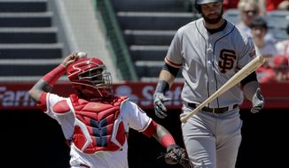 San Francisco Giants&#39; Brandon Belt, right, reacts after hitting a foul ball during the first inning of a baseball game against the Los Angeles Angels in Anaheim, Calif., Sunday, April 22, 2018. (AP Photo/Chris Carlson)