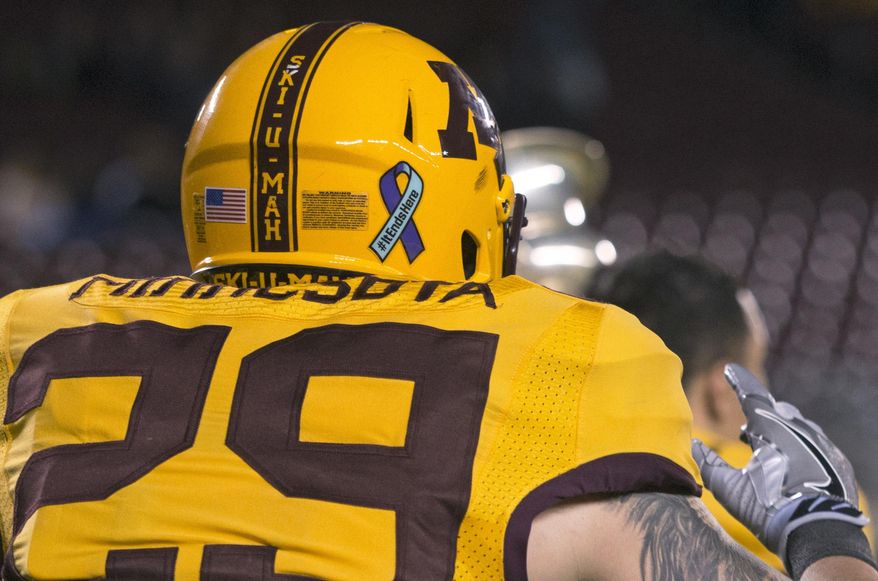 In this April 12, 2018 photo, Gophers football players wore ribbons on their helmets in support of University of Minnesota’s Student Association's It Ends Here campaign during the spring game at TCF Bank Stadium in Minneapolis. Minnesota Daily reports that the “It Ends Here” campaign aims to raise awareness and provide resources to the campus community about sexual misconduct, consent and bystander intervention. (Jack Rodgers/The Minnesota Daily via AP)