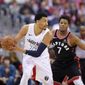 Washington Wizards forward Otto Porter Jr. (22) handles the ball against Toronto Raptors guard Kyle Lowry (7) during the first half of Game 4 of an NBA basketball first-round playoff series, Sunday, April 22, 2018, in Washington. (AP Photo/Nick Wass)