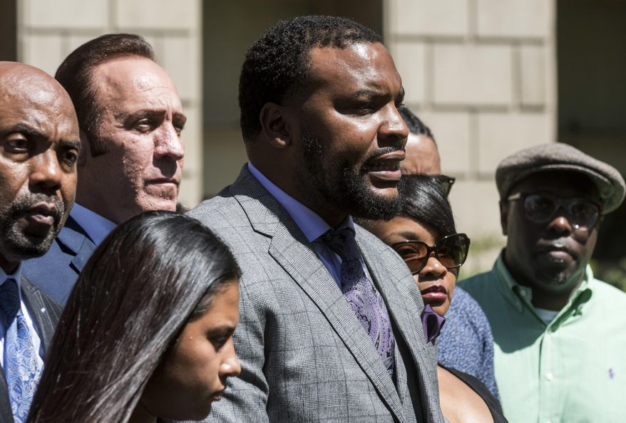 Lee Merritt, center, leads a news conference, Monday, April 23 2018, in San Bernardino, Calif., announcing a series of lawsuits against the Barstow Police Department regarding the shooting death of Diante "Butchie" Yarber. Family members and attorneys are disputing the official account of the fatal police shooting of Yarber, a 26-year-old black man, during a traffic stop earlier in the month in Barstow, Calif. (James Quigg/The Daily Press via AP)
