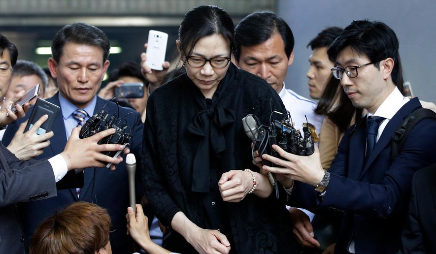 FILE - In this May 22, 2015 file photo, former Korean Air executive Cho Hyun-ah, center, is surrounded by reporters as she leaves the Seoul High Court in Seoul, South Korea. Korean Air Lines said Monday, April 23, 2018, that two daughters of its chairman will resign from their executive positions amid mounting public criticism over the women&#x27;s behavior and the family&#x27;s smuggling allegations. (AP Photo/Lee Jin-man, File)