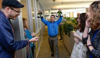 FILE - In this April 10, 2017, file photo, the Salt Lake Tribune Editor Matt Canham breaks out the champagne after their 2017 Pulitzer Prize for local reporting was announced, in Salt Like City. The Tribune newsroom takes up one floor of the building that bears its name, overlooking snow-capped mountains and the arena where the Utah Jazz play. Once a Digital First property that dealt with staff reductions and feared closure, the paper was sold to a prominent local family in 2016. Since then, its reporters received their first raise in a decade and won a Pulitzer prize for investigative reporting.  (Francisco Kjolseth/The Salt Lake Tribune via AP, File)