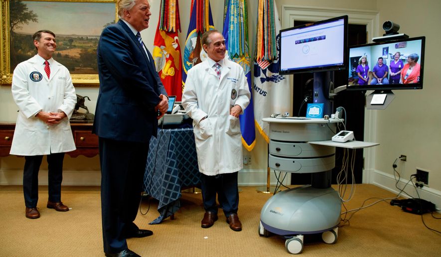 FILE - In this Aug. 3, 2017, file photo, Veterans Affairs Secretary David Shulkin, right, and White House physician Dr. Ronny Jackson, left, watch as President Donald Trump talks with a patient during a Veterans Affairs Department &amp;quot;telehealth&amp;quot; event in the Roosevelt Room of the White House in Washington. Now it’s Washington’s turn to examine Jackson. The doctor to Presidents George W. Bush, Barack Obama and now Donald Trump is an Iraq War veteran nominated to head the Department of Veterans Affairs.  (AP Photo/Evan Vucci, File)