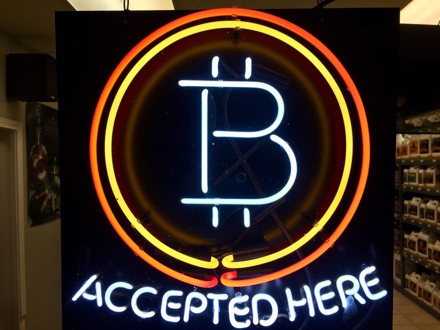 FILE - In this Feb. 7, 2018 File, photo, a neon sign hanging in the window of Healthy Harvest Indoor Gardening in Hillsboro, Ore., shows that the business accepts bitcoin as payment. The Wisconsin Ethics Commission is considering a policy guiding what to do about political contributions made in bitcoin and other cryptocurrencies. Bitcoin is gaining in popularity as a type of privately issued digital money. The Wisconsin Ethics Commission is holding a hearing Tuesday, April 24, 2018, in response to February request from the Libertarian Party of Wisconsin for public input and a policy on the use of campaigns accepting cryptocurrencies and making payments with them.(AP Photo/Gillian Flaccus File)