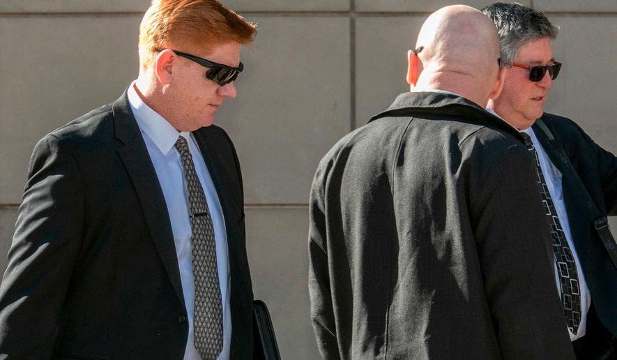 FILE - In this March 21, 2018, file photo, Border Patrol agent Lonnie Swartz, left, makes his way to the U.S. District Court building in downtown Tucson, Ariz., where opening arguments were scheduled to begin in his murder trial. A mistrial was declared Monday, April 23, in the case of Swartz after an Arizona jury acquitted him of a second-degree murder charge in the killing of a teen from Mexico but deadlocked on lesser counts of manslaughter. (Ron Medvescek/Arizona Daily Star via AP, File)