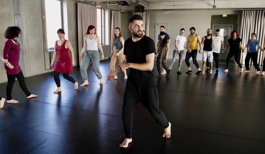 In this Sunday, April 15, 2018 photo Medhat Aldaabal, a Syrian migrant from Damascus, shows dance moves at a workshop to learn the traditional Arab dance Dabke in Berlin, Germany. (AP Photo/Jona Kallgren)