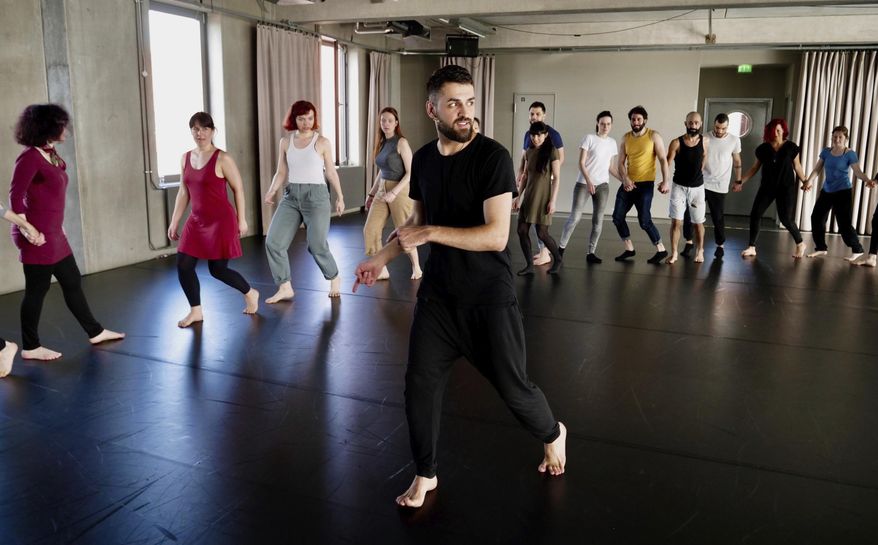 In this Sunday, April 15, 2018 photo Medhat Aldaabal, a Syrian migrant from Damascus, shows dance moves at a workshop to learn the traditional Arab dance Dabke in Berlin, Germany. (AP Photo/Jona Kallgren)