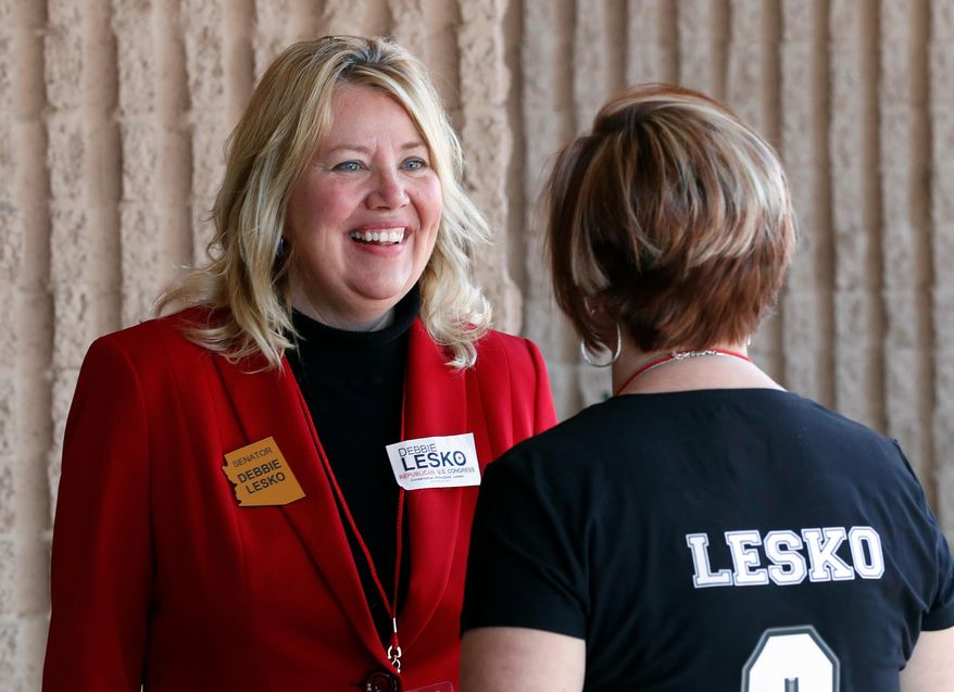 FILE - In this Jan. 27, 2018, file photo, former Arizona state Sen. Debbie Lesko speaks with a constituent during the meeting of the state committee of the Arizona Republican Party in Phoenix. Lesko is running against Hiral Tipirneni in a special election, Tuesday, April 24, to fill the U.S. House seat vacated by Republican Rep. Trent Franks. (AP Photo/Matt York, File)