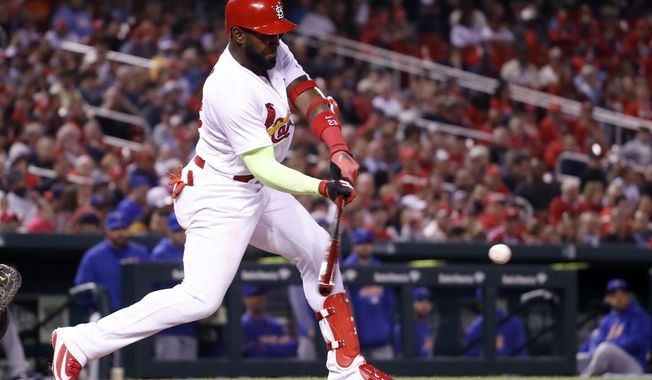 St. Louis Cardinals&#x27; Marcell Ozuna hits a two-run single during the third inning of a baseball game against the New York Mets on Wednesday, April 25, 2018, in St. Louis. (AP Photo/Jeff Roberson)