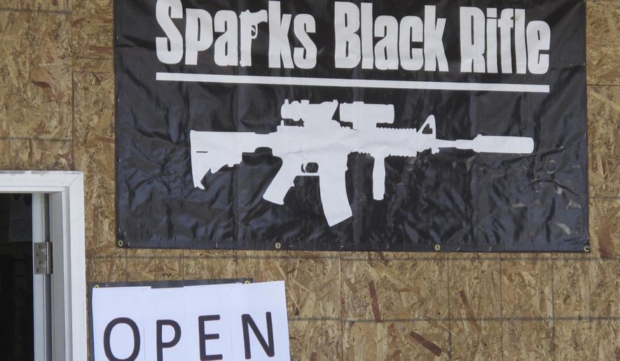 The Sparks Black Rifle gun store is pictured in this photo taken Wednesday, April 25, 2018 in Sparks, Nevada. The store's emblem was on one of two t-shirts worn by an 8th grade student who has filed a lawsuit in federal court in neighboring Reno alleging the Washoe County School District violated his constitutional rights when he was disciplined for wearing pro-gun attire in violation of the district's dress code. The front of the store has been boarded up since thieves drove a car through the glass entry way and made off with weapons. (AP Photo/By Scott Sonner).