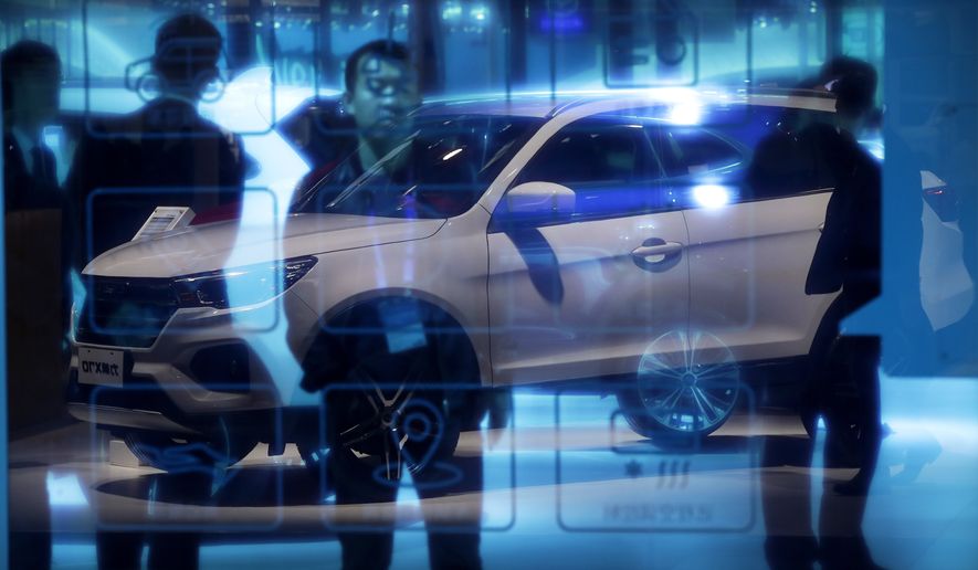 Chinese visitors stand near a glass panel reflecting a Chinese auto brand Lifan X70 SUV on display at the China Auto Show in Beijing, Thursday, April 26, 2018. Auto China 2018, the industry's biggest sales event this year, is overshadowed by mounting trade tensions between Beijing and U.S. President Donald Trump, who has threatened to hike tariffs on Chinese goods including automobiles in a dispute over technology policy. (AP Photo/Andy Wong)