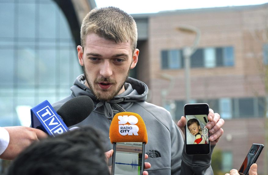 Tom Evans holds up his phone showing a photo of his son Alfie as he speaks to the media outside Alder Hey Children's Hospital where the 23-month-old who has been at the centre of a life-support treatment dispute, in Liverpool, England, Thursday April 26, 2018. (Peter Byrne/PA via AP)
