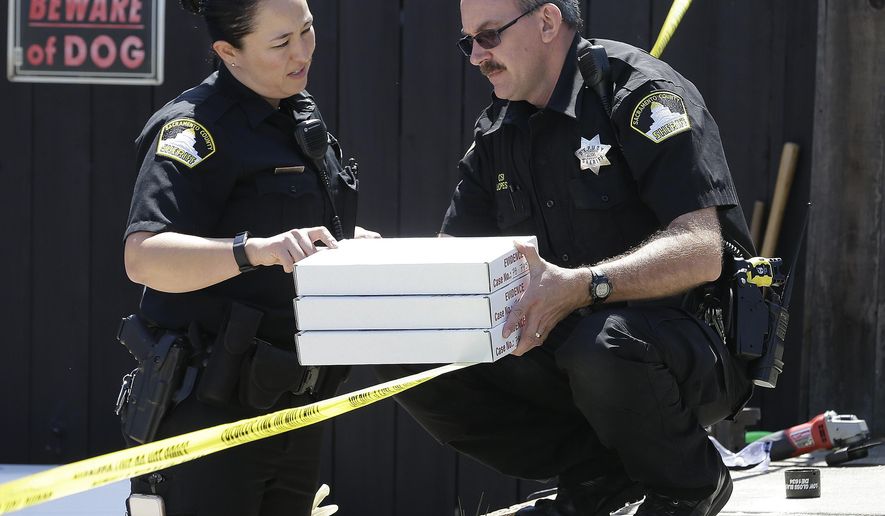 T. Abbott, left, and John Lopes, right, from the Sacramento County Sheriff's crime scene investigation office, conference about boxes of evidence gathered from the home of murder suspect Joseph DeAngelo, Thursday, April 26, 2018, in Citrus Heights, Calif. DeAngelo, 72, was taken into custod Tuesday on suspicion of committing multiple homicides and rapes in the 1970s and 1980s in California. Authorities spent the day going through the home for evidence. (AP Photo/Rich Pedroncelli)