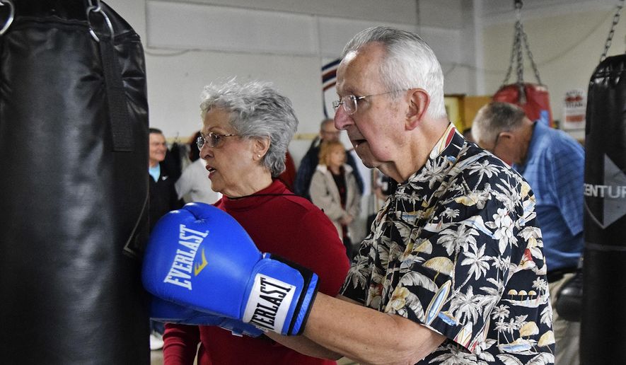 In this April 14, 2018, photo, Melvin Siverly hits the bag during the Rock Steady Boxing workout at the Weinberg Arcade in Galesburg, Ill. The class helps build strength, coordination and balance for people with Parkinson's disease. (Bill Nice/The Register-Mail via AP)