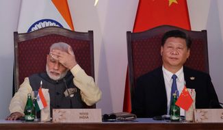 In this Oct. 16, 2016, file photo, Indian Prime Minister Narendra Modi, left, and Chinese President Xi Jinping attend the BRICS summit in Goa, India. Modi is travelling April 27-28, 2018 to meet with Xi for a visit that some experts have described as a possible way to reset a complicated relationship between the two Asian powers that has faced several tests last year, including a tense border standoff. (AP Photo/Manish Swarup, File)