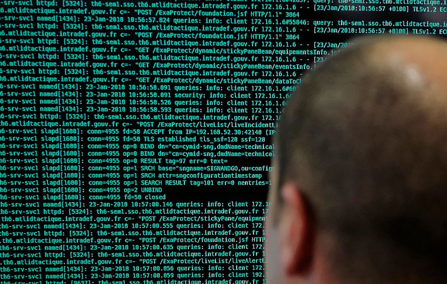 In this Jan.23 2018 file photo, a French solider watches code lines on his computer at the French Defense ministry stand during the International Cybersecurity forum in Lille, northern France. (AP Photo/Michel Spingler, File)